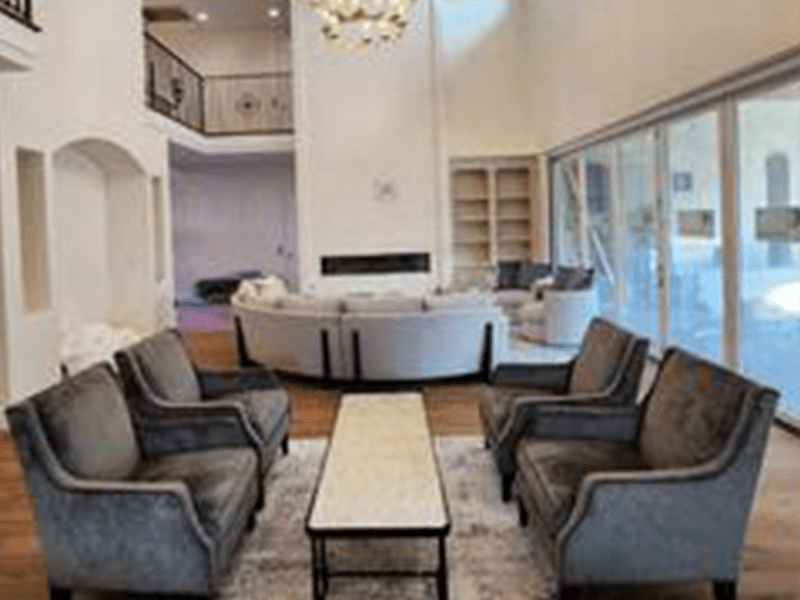 Spacious living room featuring elegant gray armchairs